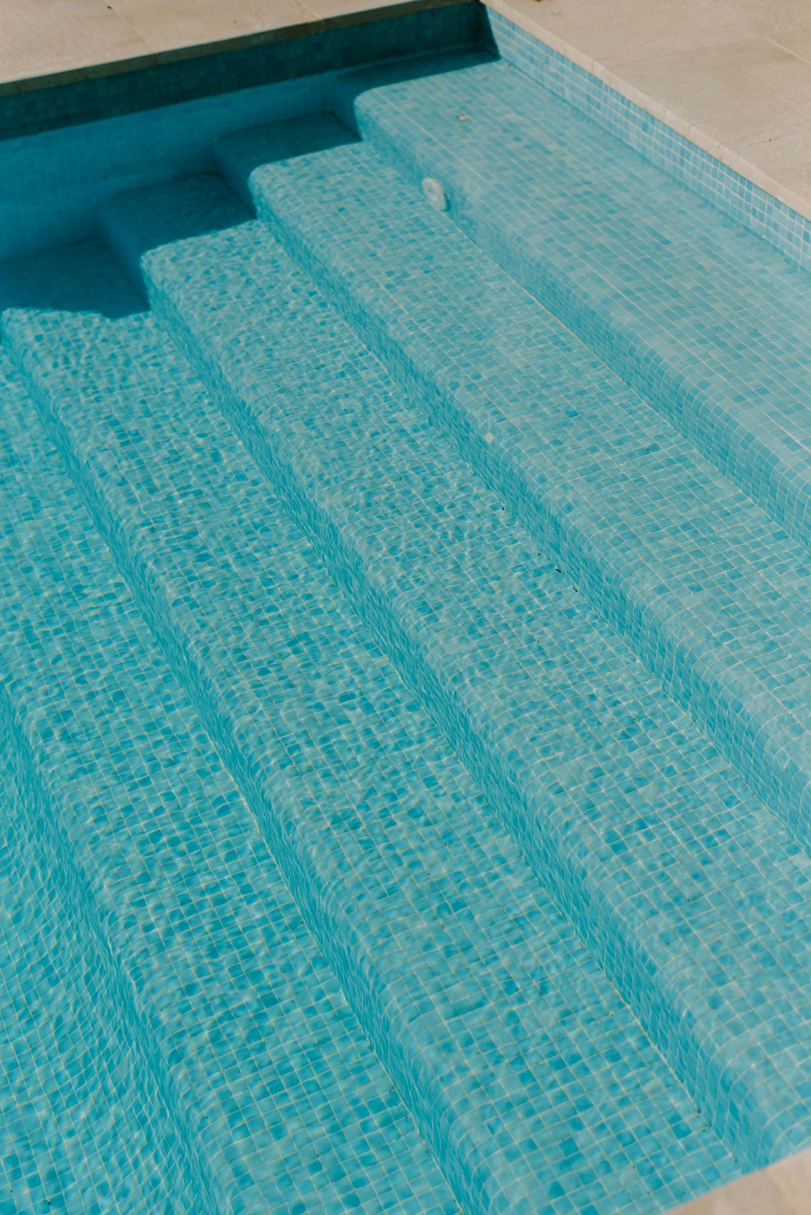 Swimming pool steps finished in small mosaic tile